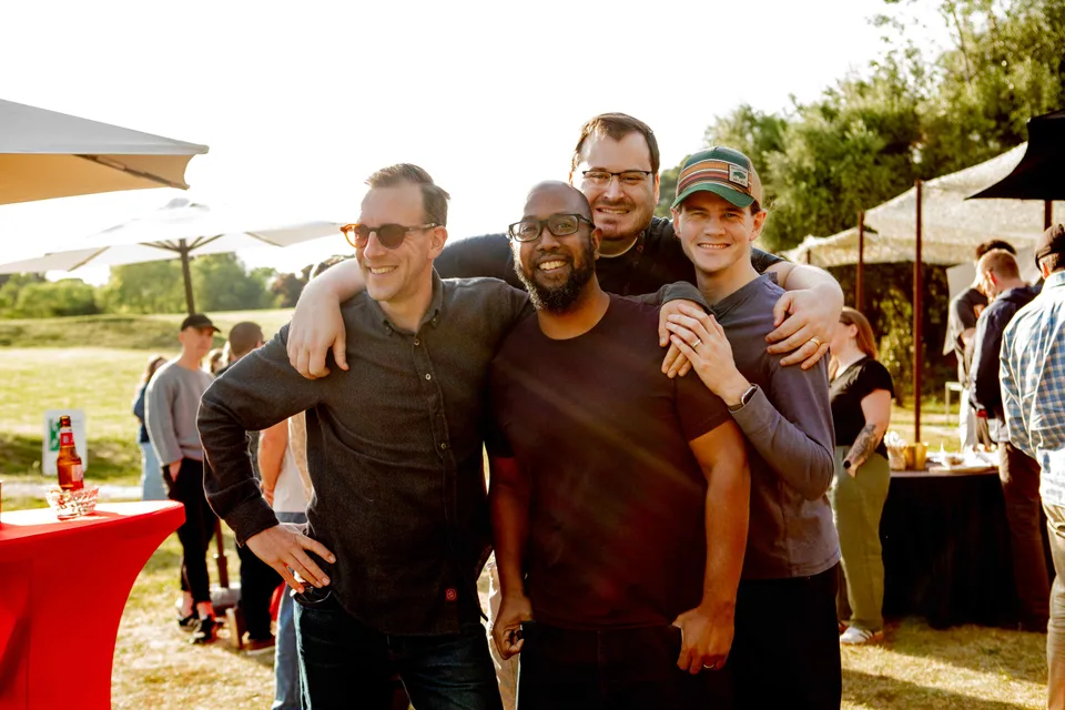 Four Close teammates posing arm in arm in the sunshine