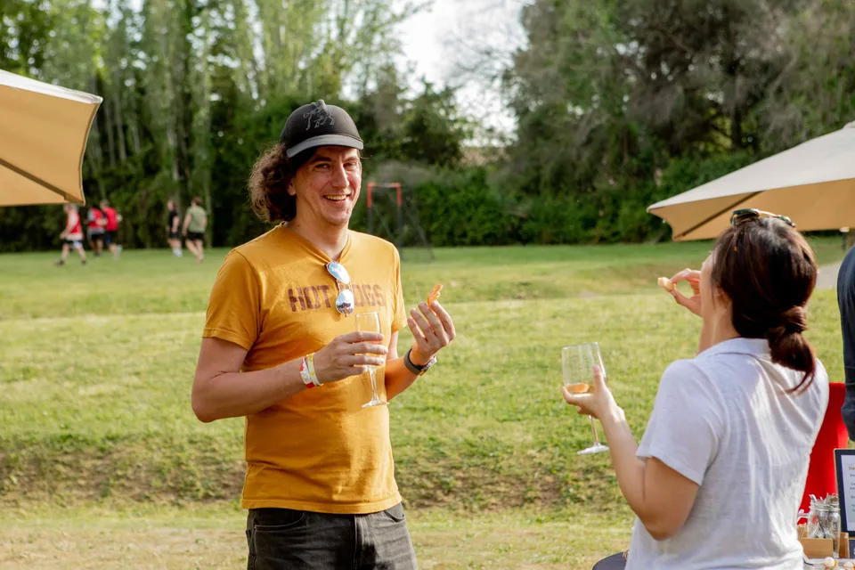 A Close teammate in a mustard t-shirt chatting on the lawn