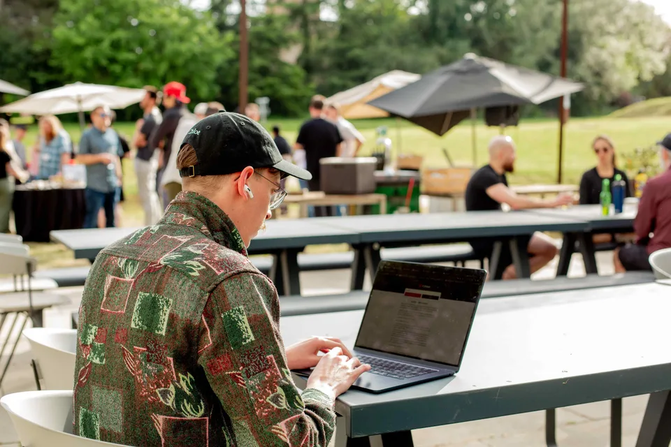 A Close teammate working on a laptop at an outdoor table