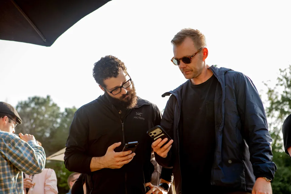 Two Close teammates comparing something on their phones