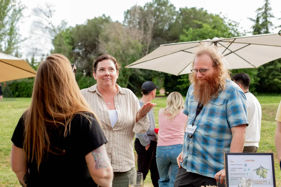 Close teammates deep in conversation on the lawn at the annual retreat